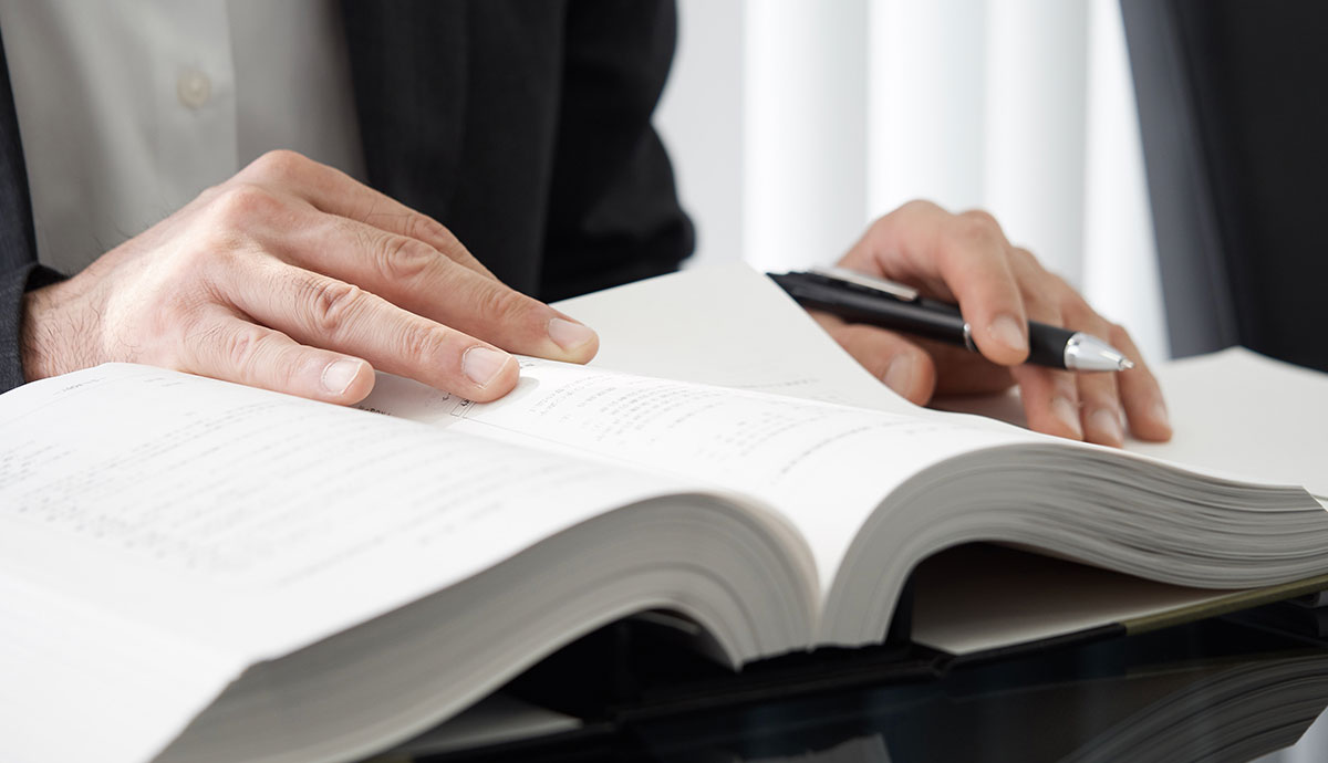 professional looking at open book on table